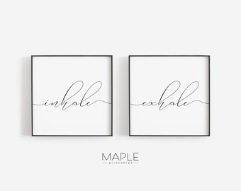 May include: Two black framed prints with white backgrounds. The left print has the word "inhale" written in cursive. The right print has the word "exhale" written in cursive.