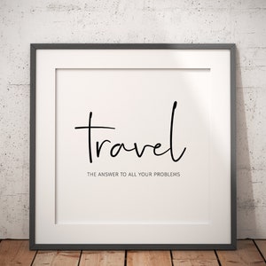 May include: Framed print with the word "travel" in a handwritten font. Below, the text reads "THE ANSWER TO ALL YOUR PROBLEMS". The print is in a black frame, set against a white background and a textured wall.