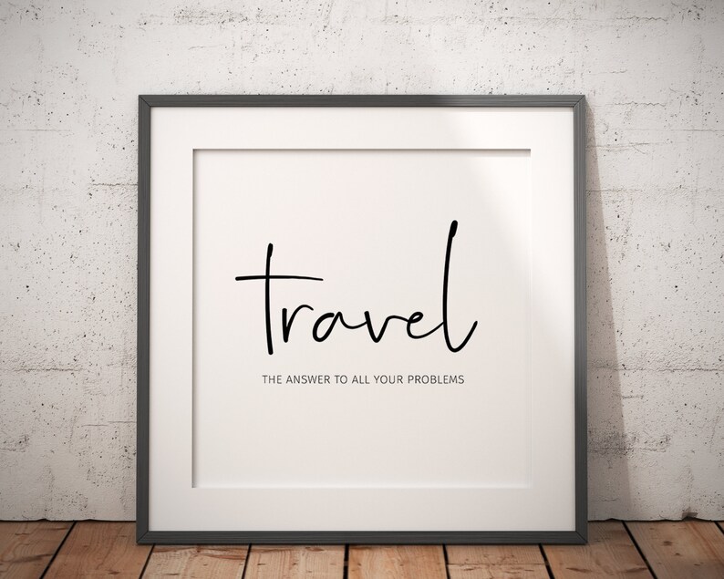 May include: Framed print with the word "travel" in a handwritten font. Below, the text reads "THE ANSWER TO ALL YOUR PROBLEMS". The print is in a black frame, set against a white background and a textured wall.