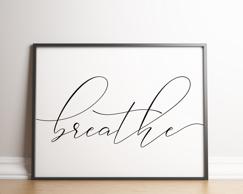 May include: A black and white printable wall art print with the word "breathe" written in cursive script.