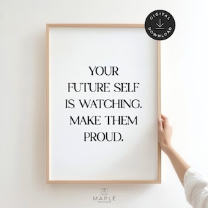 May include: A framed print with the text "YOUR FUTURE SELF IS WATCHING. MAKE THEM PROUD." The print has a white background with black text and a light brown frame. A black circle with "DIGITAL DOWNLOAD" is in the top right corner.