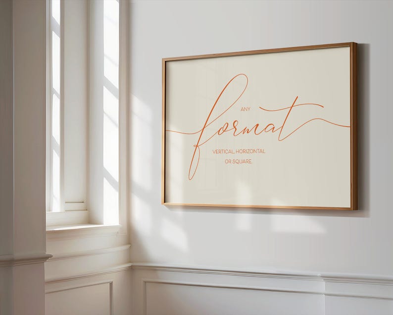 May include: A framed print with a light beige background and a handwritten orange script that says "any format" with the words "vertical, horizontal, or square" written below in smaller font.