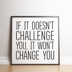 May include: Black and white motivational quote in a black frame on a white wall. The quote reads "If it doesn't challenge you, it won't change you."