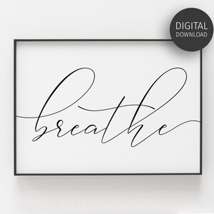 May include: A black and white printable wall art print with the word "breathe" written in a cursive font.