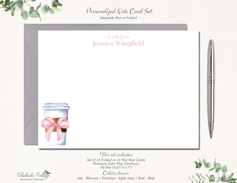 May include: A personalised note card set featuring a watercolour illustration of a coffee cup with a pink bow. The set includes 10 folded or 12 flat note cards and envelopes. The note cards are 10.8 cm by 14 cm. The text "a note from Jessica Wingfield" is at the top of the card. The text "This set includes: Set of 10 Folded or 12 Flat Note Cards Premium Euro Flap Envelopes A2 Size (4.25" x 5.5") Colors shown: Ink: Blossom | Envelope: Light Grey | Bow: Pink" is at the bottom of the card.