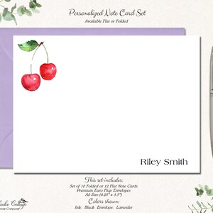 May include: Personalized note card set with a watercolor illustration of two red cherries. The set includes 10 folded or 12 flat note cards and premium Euro flap envelopes. The cards are A2 size (4.25" x 5.5"). The ink color is black and the envelope color is lavender. The name "Riley Smith" is printed on the card.