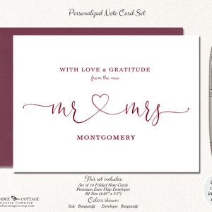 Puede incluir: Un juego de tarjetas de notas personalizadas con tinta y sobre color burdeos. La tarjeta presenta el texto "WITH LOVE & GRATITUDE from the new mr & mrs MONTGOMERY". Un bol&iacute;grafo plateado descansa a la derecha.