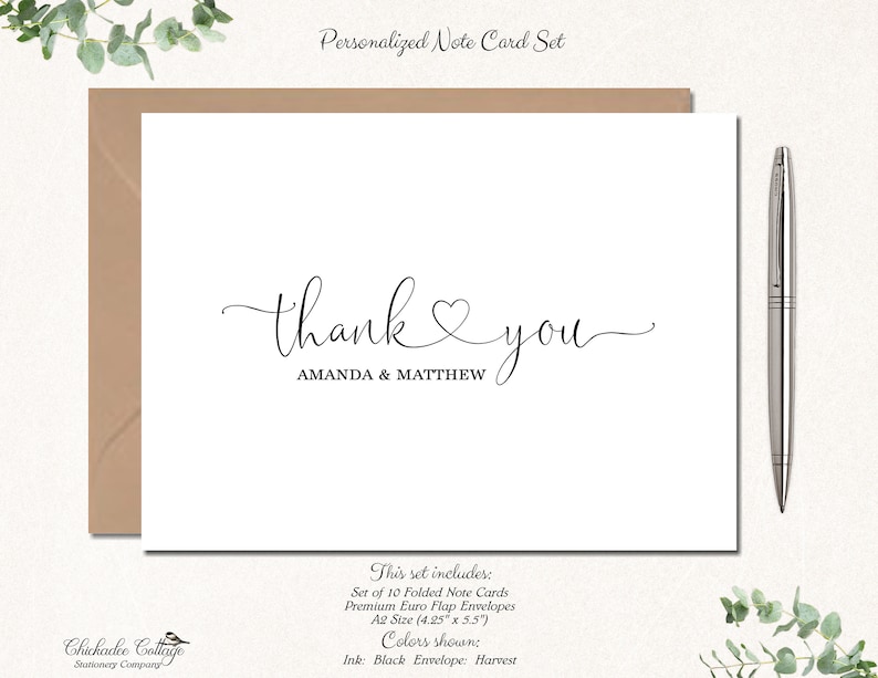 May include: A personalized note card set featuring a white card with the words "thank you" in elegant script, with the names "AMANDA & MATTHEW" below. The set includes a brown envelope and a silver pen. The card size is 4.25" x 5.5".