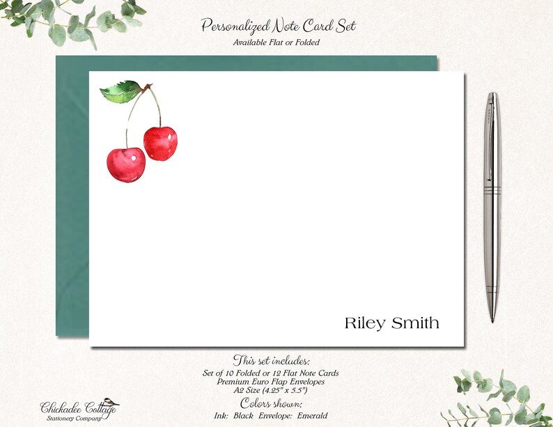 May include: Personalized note card set with a watercolor illustration of two red cherries. The set includes 10 folded or 12 flat note cards and premium Euro flap envelopes in A2 size (4.25" x 5.5"). The ink is black and the envelope is emerald.