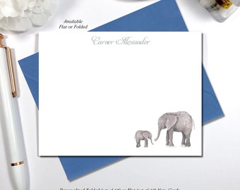 May include: Personalized note cards with a watercolor illustration of two elephants. The text "Carver Alexander" is printed in gray at the top of the card. The note cards are available in sets of 10 folded or 12 flat cards. The envelope color is sea.