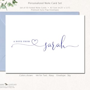 May include: A white note card with navy blue text that reads "A NOTE FROM" followed by the name "sarah" in cursive. The card is inside a light blue envelope. The text color is navy, and the envelope color is sky.