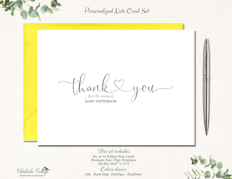May include: A personalized note card set with a white card featuring the words "thank you" in elegant script, with "from the nursery of BABY PATTERSON" below. The card is set against a bright yellow envelope, with a silver pen and greenery. The set includes 10 folded cards.