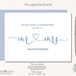Puede incluir: Un juego de tarjetas de notas personalizadas con un sobre azul. La tarjeta presenta el texto "WITH LOVE & GRATITUDE from the new mr & mrs MONTGOMERY" en una elegante fuente azul. Un bol&iacute;grafo plateado descansa a la derecha. El juego incluye 10 tarjetas plegadas, sobres premium, tama&ntilde;o A2 (10,8 cm x 14 cm).