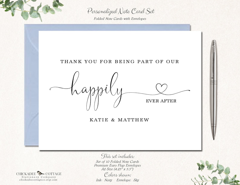 May include: A personalized note card set with a white card and a light blue envelope. The card reads "THANK YOU FOR BEING PART OF OUR happily EVER AFTER" with the names KATIE & MATTHEW. A silver pen rests on the right.