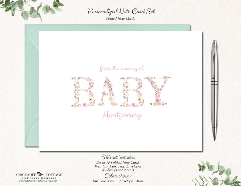 May include: Set of 10 folded note cards with floral lettering spelling "BABY" and the name "Montgomery". The cards are 4.25 inches by 5.5 inches and come with premium euro flap envelopes. The ink color is blossom and the envelope color is mint.
