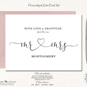 Puede incluir: Un juego de tarjetas de notas personalizadas con un sobre color rubor. La tarjeta presenta las palabras "WITH LOVE & GRATITUDE" y "mr & mrs MONTGOMERY" en una elegante escritura negra. Un bol&iacute;grafo plateado descansa a la derecha.