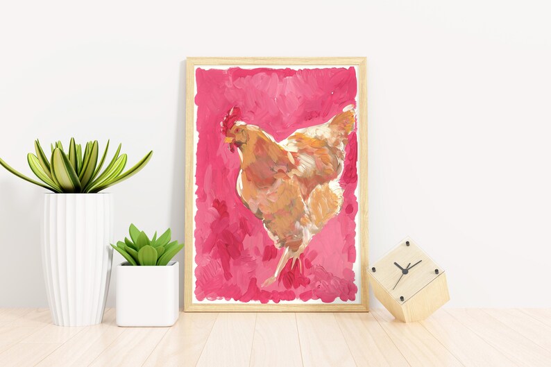 Puede incluir: Una pintura de una gallina marr&oacute;n sobre un fondo rosa. La gallina est&aacute; mirando hacia el lado izquierdo de la imagen y tiene las alas extendidas. La pintura est&aacute; enmarcada en un marco de madera claro.