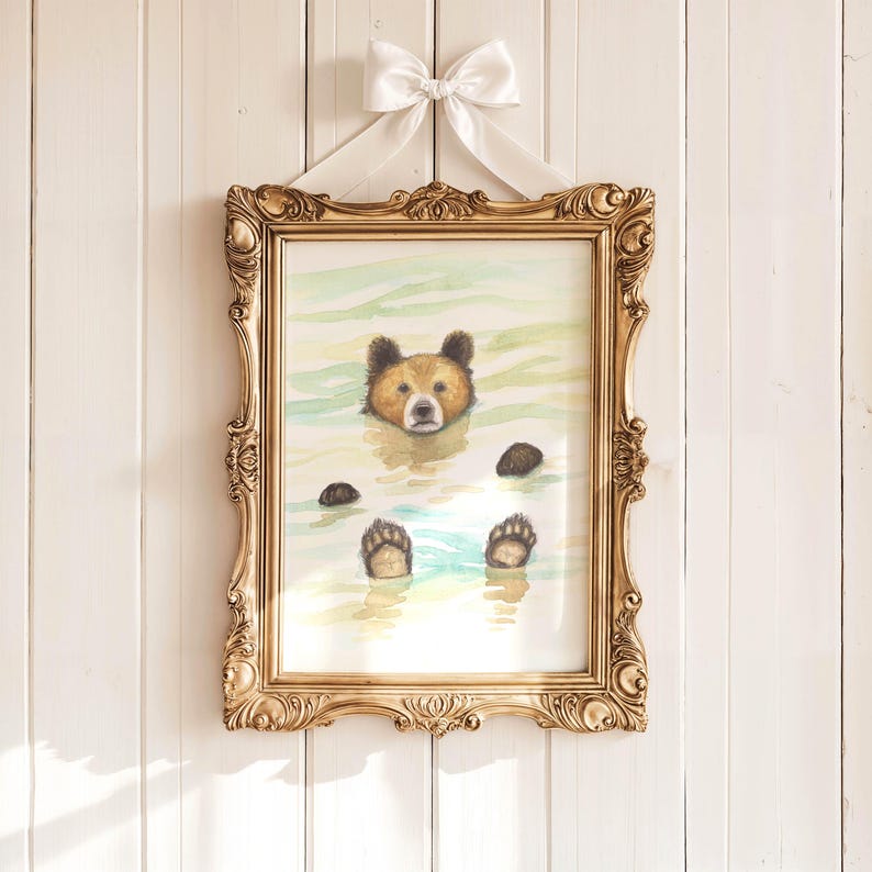 May include: A watercolor painting of a brown bear floating in a body of water. The bear is looking directly at the viewer with its paws outstretched. The painting is framed in a gold ornate frame.