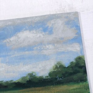 May include: A painting depicting a landscape with a field of green grass, a line of trees in the background, and a blue sky with white clouds.