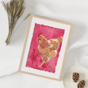 Puede incluir: Una pintura enmarcada de una gallina marr&oacute;n sobre un fondo rosa. La gallina est&aacute; mirando hacia el lado derecho del marco y tiene la cabeza girada hacia la izquierda. La pintura est&aacute; en un marco de madera claro.