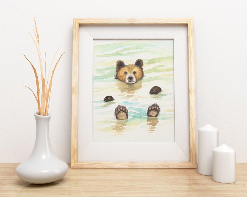 May include: Watercolor painting of a brown bear floating in a body of water. The bear's head is above the water and its paws are submerged. The water is a light blue color and the background is a light green.