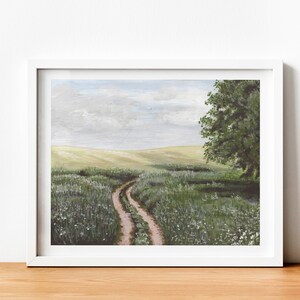 May include: A painting of a dirt road winding through a field of green grass and white wildflowers. A large tree stands on the right side of the road. The sky is a light blue with white clouds.