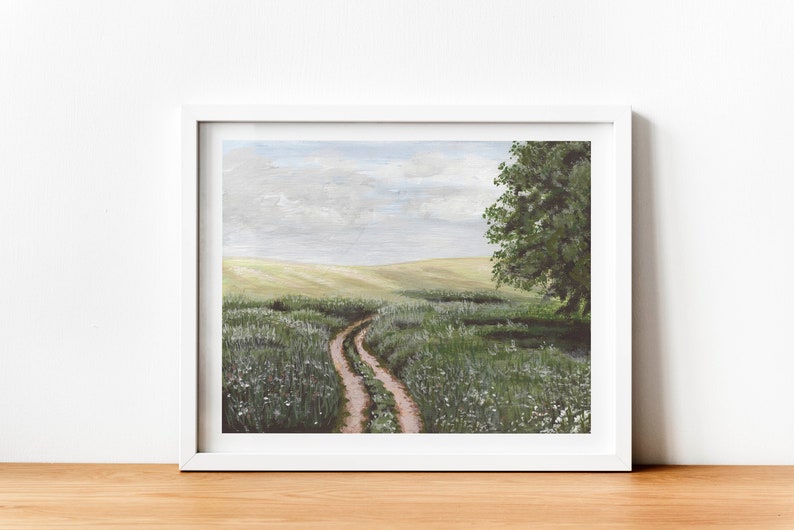 May include: A painting of a dirt road winding through a field of green grass and white wildflowers. A large tree stands on the right side of the road. The sky is a light blue with white clouds.
