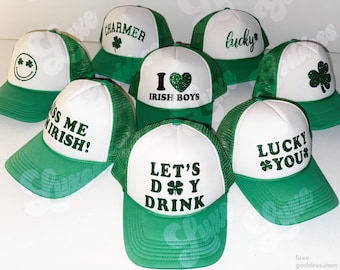 Puede incluir: Una colección de ocho gorras de camionero verdes y blancas con varios diseños y textos temáticos del Día de San Patricio, que incluyen "Charmer", "I Love Irish Boys", "Kiss Me Irish", "Lucky", "Lucky You" y "Let's D'Y Drink".