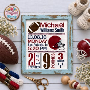 May include: A framed cross-stitch birth announcement featuring a football theme with the name Michael Williams Smith, birth date 13.08.16, Monday, San Antonio, Tx, 5:20 PM, and birth stats of 21 1/2 inches and 9 pounds 3 ounces in red and blue.