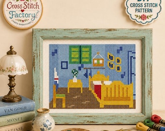 May include: A framed cross stitch artwork depicting a bedroom scene with a yellow bed, green shutters, and a chair. The piece is displayed alongside a small lamp, a stack of books, a paint palette, scissors, a thimble, and colorful embroidery threads.