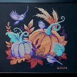 May include: Embroidered artwork featuring a trio of pumpkins in shades of orange, purple, and blue, surrounded by wheat stalks, leaves, and birds. The artwork is framed in black and includes the date "@2024".