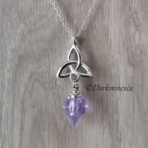 May include: A silver chain necklace with a Celtic knot pendant and a purple crystal charm.