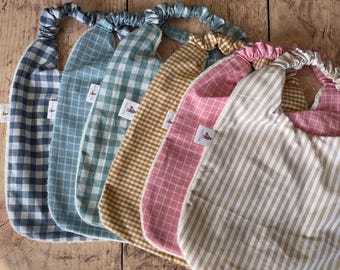 Elastyczny śliniaczek w kwiaty dla niemowląt i dzieci, wykonany z podwójnej gazy z certyfikatem Oeko-Tex. Idealny do żłobków i szkolnych stołówek; łatwy do zakładania, miękki i chłonny.