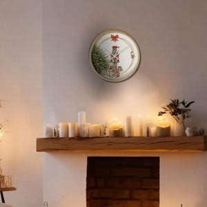 Könnte beinhalten: Ein gemütliches Wohnzimmer mit Kamin, Kerzen und einer Weihnachtsuhr. Die Uhr hat ein festliches Design mit einem Weihnachtsbaum. Die sanfte Beleuchtung des Raumes schafft eine einladende Atmosphäre.