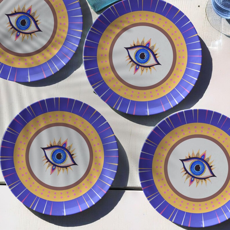 Polymer dinner plate with bold evil eye artwork and radiant accents, set of 4 on outdoor setting showing durability