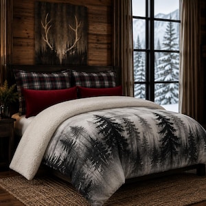 Peut inclure: Une parure de lit comprenant une couette avec un imprimé forêt en noir et blanc et une doublure en sherpa crème. L'ensemble inclut deux oreillers à motif écossais et deux oreillers rectangulaires rouge foncé sur un cadre de lit en bois.
