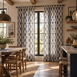 May include: A pair of floor-length curtains featuring a repeating navy blue fish pattern on a cream-colored fabric. The curtains are hung from a dark metal rod using fabric loops, covering a tall window that allows natural light to filter through.