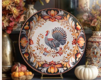 May include: A round ceramic plate featuring a central illustration of a turkey surrounded by an intricate border of orange, red, and black floral and leaf motifs. The plate has a white background and a dark, decorative rim with repeating patterns.