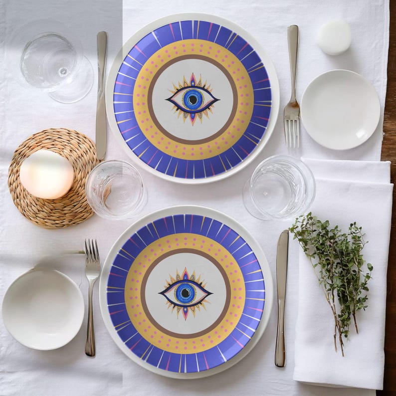 Dinner plate with evil eye design in blue, gold, and purple, placed on elegant table setting