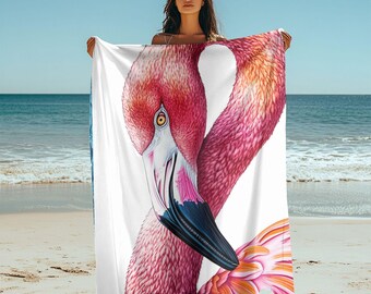 Op de afbeelding: Een witte strandhanddoek met een roze flamingo-illustratie. De flamingo is afgebeeld met zijn kop naar beneden gebogen, zijn snavel raakt zijn veren. De flamingo heeft de vorm van een hart.
