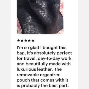 May include: A dark navy blue tote bag with a textured crocodile skin pattern, featuring two sturdy shoulder straps and a visible snap button closure at the top. The interior contains a light-colored fabric pouch with the text JUAN visible.