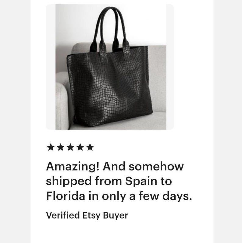 May include: A black tote bag featuring a textured crocodile skin pattern. The bag has two tall, sturdy handles attached to the top edge, a rectangular silhouette, and a spacious main compartment with a clean, structured design for daily use.