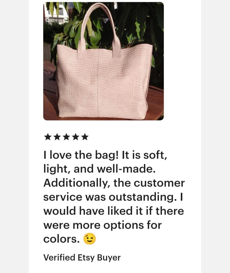 May include: A light pink tote bag featuring a textured, embossed crocodile skin pattern. The bag has two matching top handles and a rectangular silhouette with a vertical seam running down the center of the front panel.
