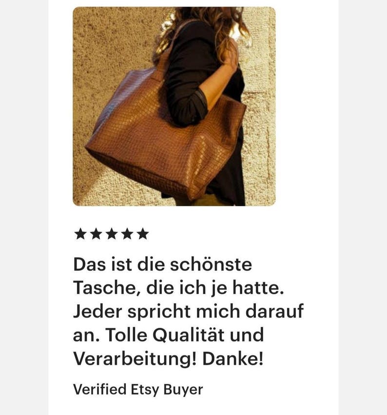 May include: A large, brown, rectangular tote bag with a textured, embossed surface pattern. The bag features two sturdy shoulder straps and is carried at the side, showcasing its structured shape and deep, warm brown color against a textured wall.