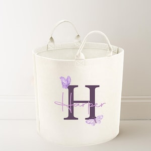 May include: A white canvas storage bin with two handles. The bin has a purple letter H and the name Harper written in cursive below it. There are two purple butterflies on either side of the letter.
