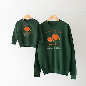 May include: Two green sweatshirts with pumpkin designs. The larger sweatshirt says "mamma to the cutest pumpkin Mommy & Belle". The smaller sweatshirt says "mommy's little pumpkin Isabelle".