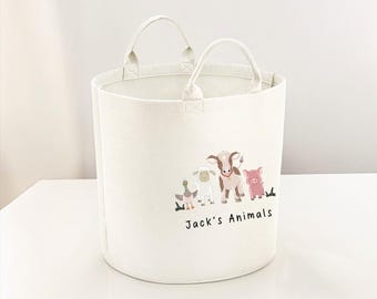 May include: A white canvas storage bin with two handles. The bin has a graphic of a duck, sheep, cow, and pig with the text "Jack's Animals".