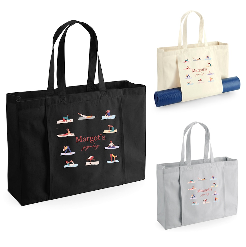 May include: A set of three rectangular tote bags in black, cream, and gray, each featuring two handles and a central graphic of various yoga poses surrounding the red text "Margot's yoga bag". One cream bag holds a rolled blue yoga mat.