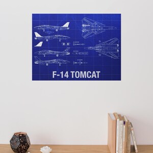 May include: A blueprint-style print featuring multiple views of an F-14 Tomcat fighter jet against a blue grid background. The text "F-14 TOMCAT" is displayed in white at the bottom. The print showcases the aircraft's design.