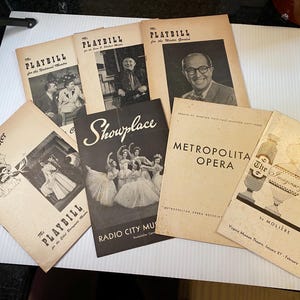May include: A collection of vintage playbills and programs, including "Playbill" for various theaters, "Showplace" from Radio City Music Hall, and "Metropolitan Opera." The covers feature black and white photos and text.